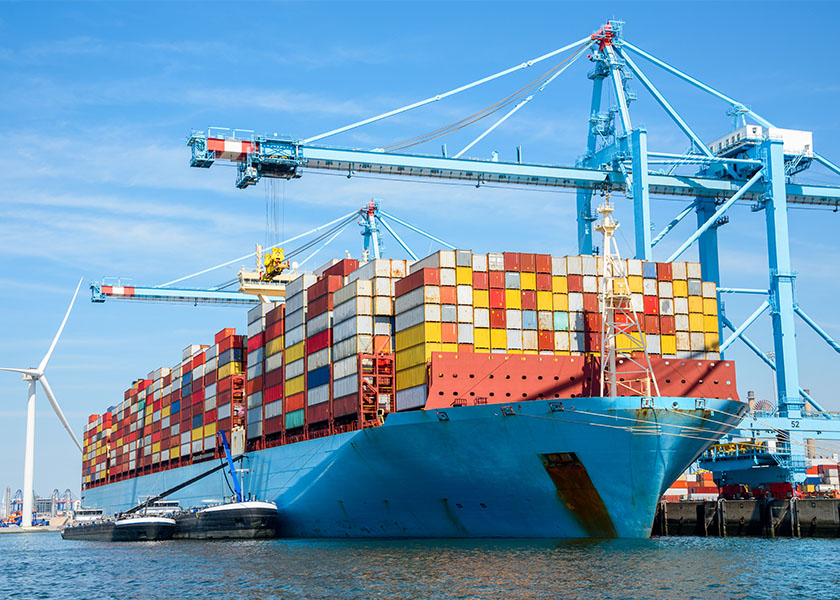 A stock market chart reflecting volatility amid tariff uncertainty, with cargo containers in the background symbolizing global trade tensions.